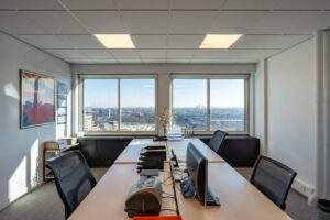 Modern kantoor met uitzicht op het Koningin Wilhelminaplein en de skyline van Amsterdam.